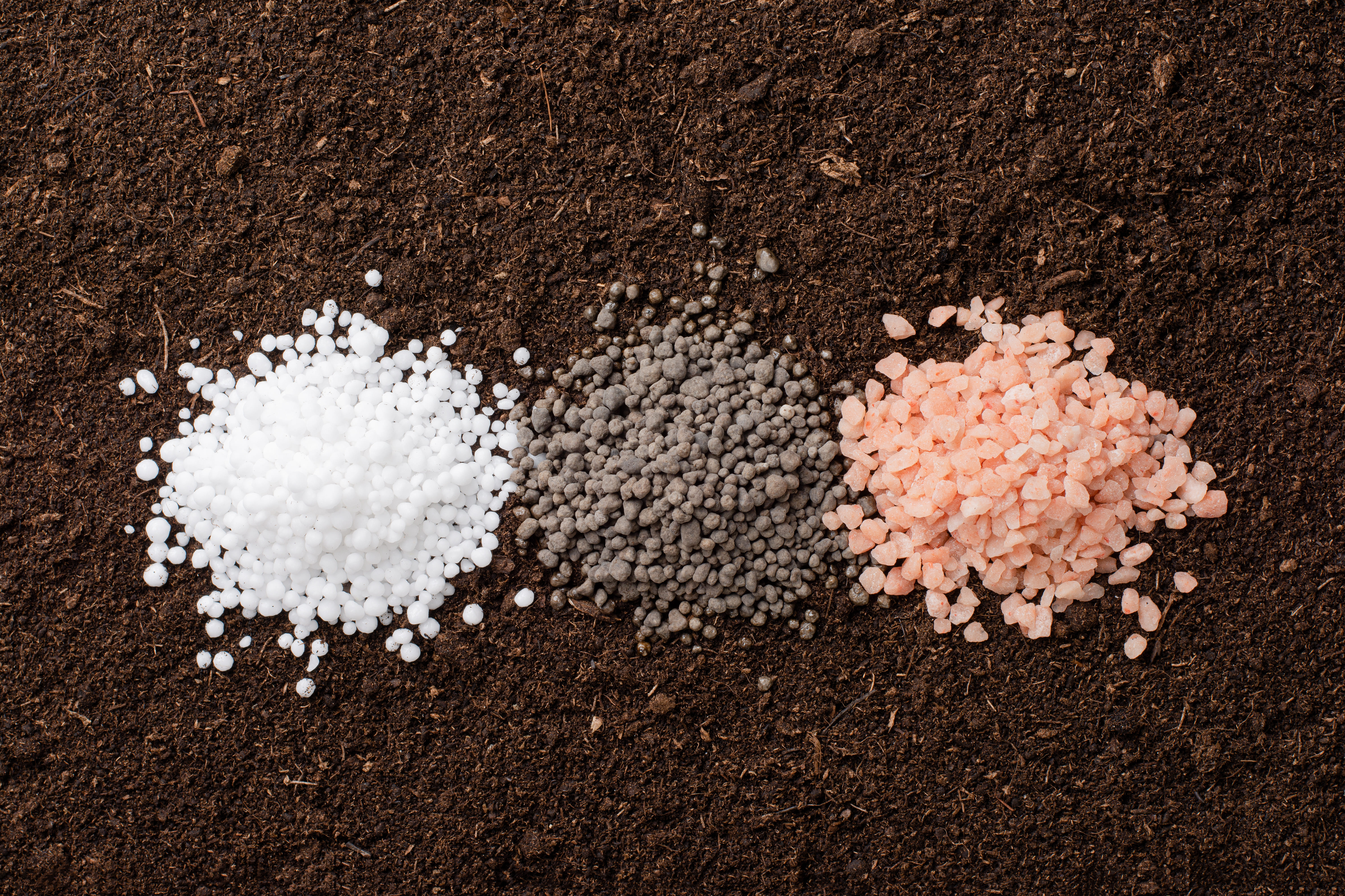 Drei verschiedenfarbige NPK-Düngergranulate – veredelt mit Semfill für optimale Verteilung und Qualität